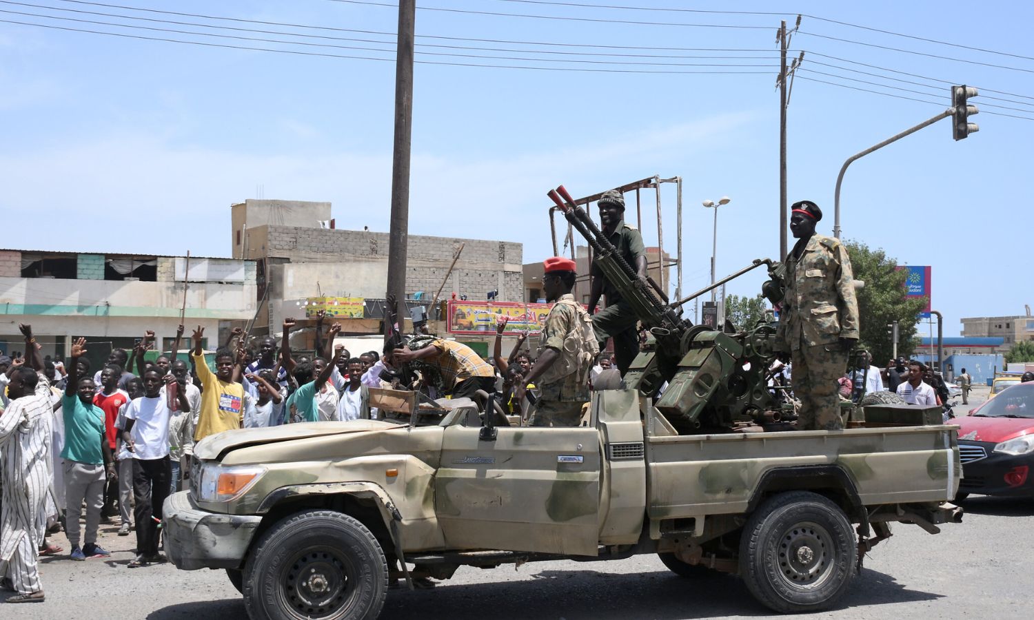 مواطنون سودانيون يحيون جنود من الجيش السوداني نيسان 2023 (AFP)