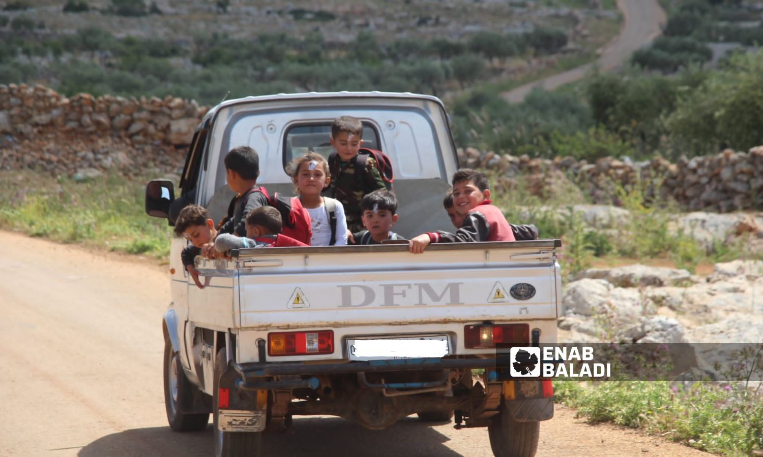 أطفال يركبون سيارة تنقلهم من المدرسة إلى مخيم بريف إدلب الشمالي - 1 من أيار 2023 (عنب بلدي/ إياد عبد الجواد)
