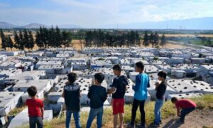 أطفال سوريون على تلة فوق مخيم للاجئين في بلدة بر الياس في سهل البقاع اللبناني ، 13 يونيو AP) 2023)