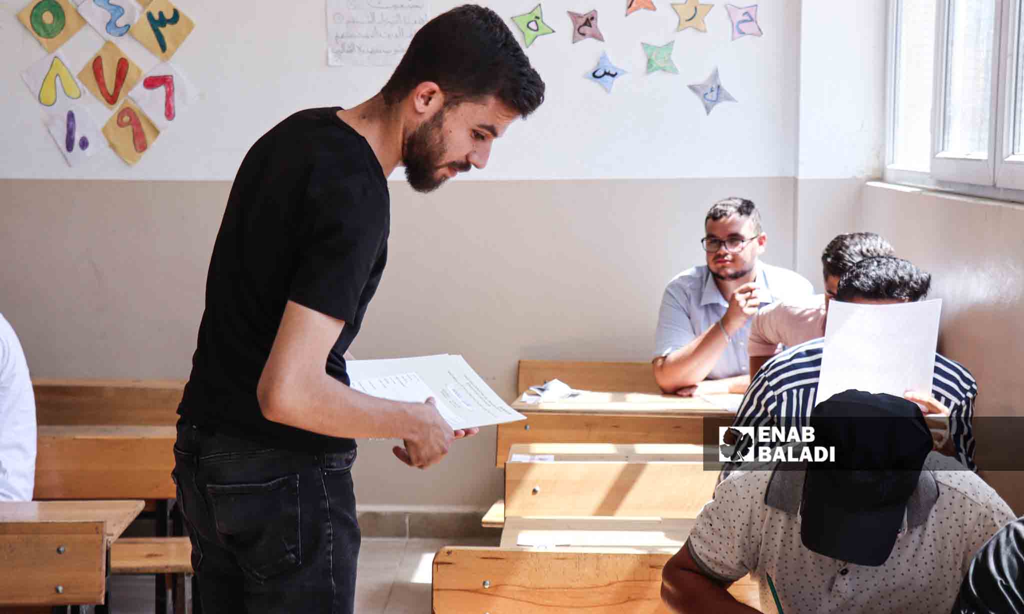 أثناء توزيع الأوراق الامتحانية على طلاب الشهادة الثانوية - 5 من تموز 2023 (عنب بلدي/ حسين شعبو)  