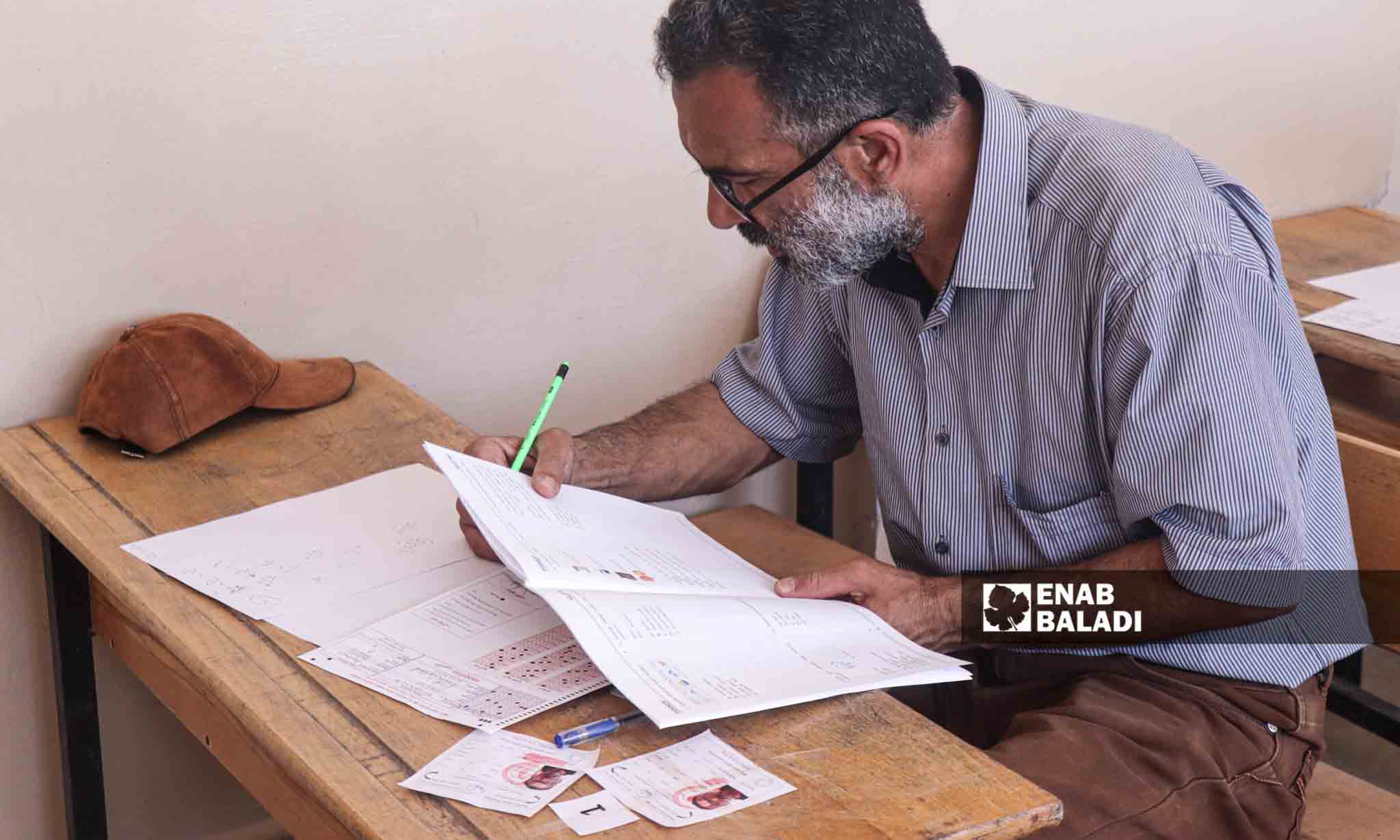 رجل كبير بالسن يقدم امتحان الثانوية - 5 من تموز 2023 (عنب بلدي/ حسين شعبو)