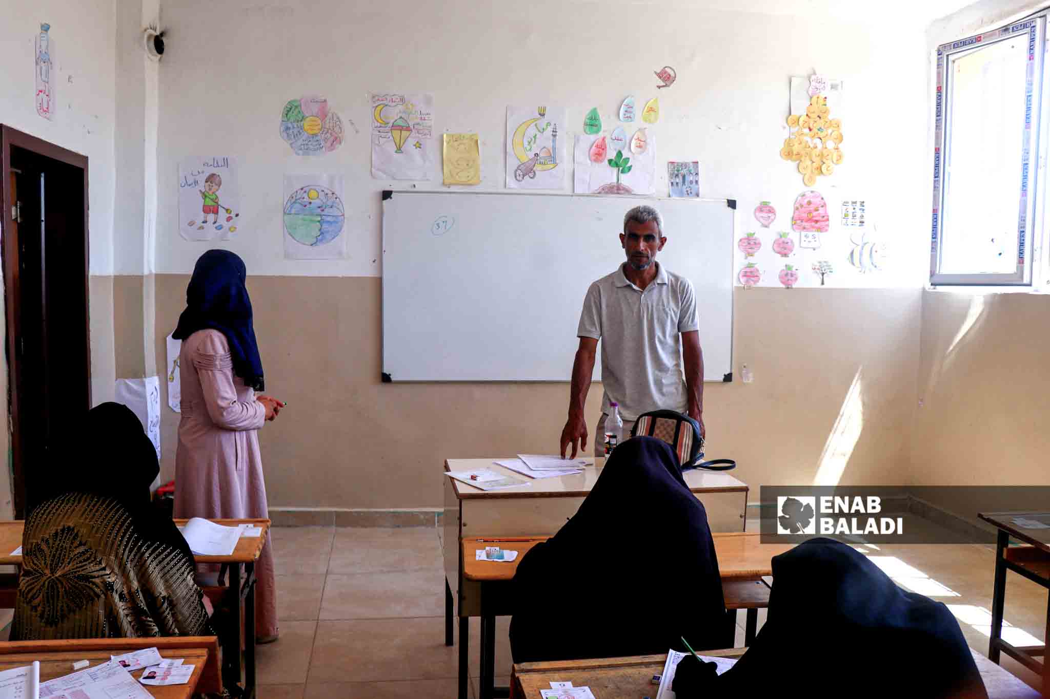 مراقب يشرح للطلاب كيفية الإجابة على أوراق الامتحان  - 5 من تموز 2023 (عنب بلدي/ حسين شعبو) 