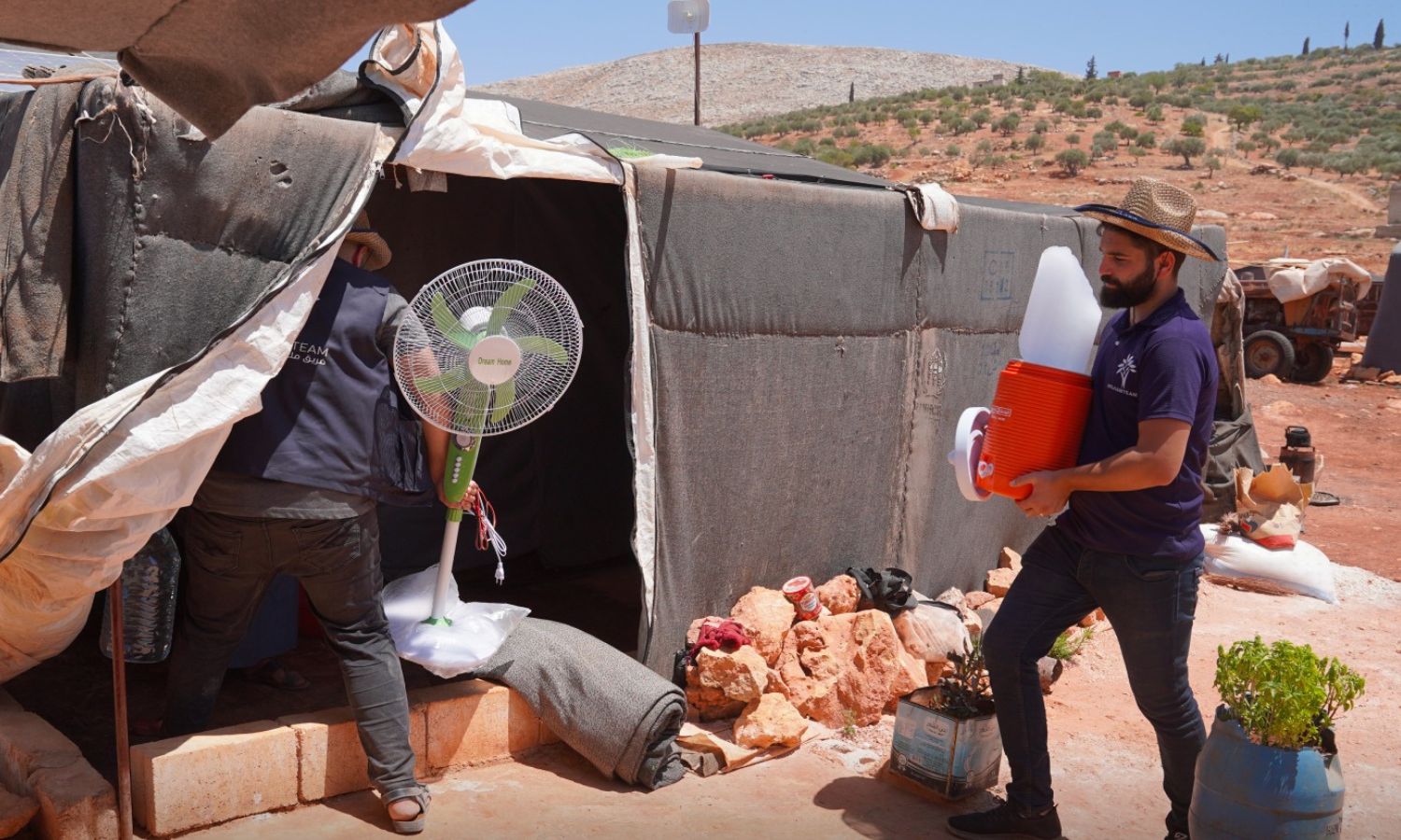 توزيع قالب ثلج ومروحة على النازحين في مخيمات الشمال السوري- 28 من تموز 2023 (فريق ملهم التطوعي)