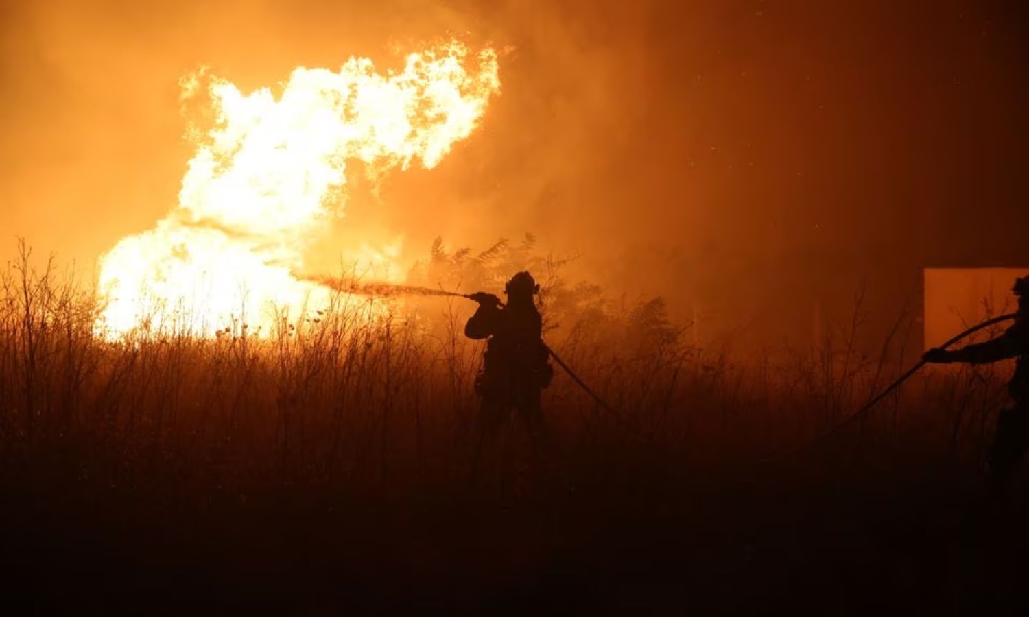 رجل إطفاء يحاول إخماد حريق غابات مشتعل قرب قرية في منطقة إيفروس اليونانية- 22 من آب 2023 (رويترز)