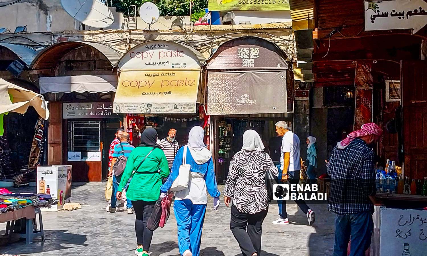 مارة أمام محال تجارية في حي القيمرية بدمشق - 26 من تموز 2023 (عنب بلدي / سارة الأحمد)
