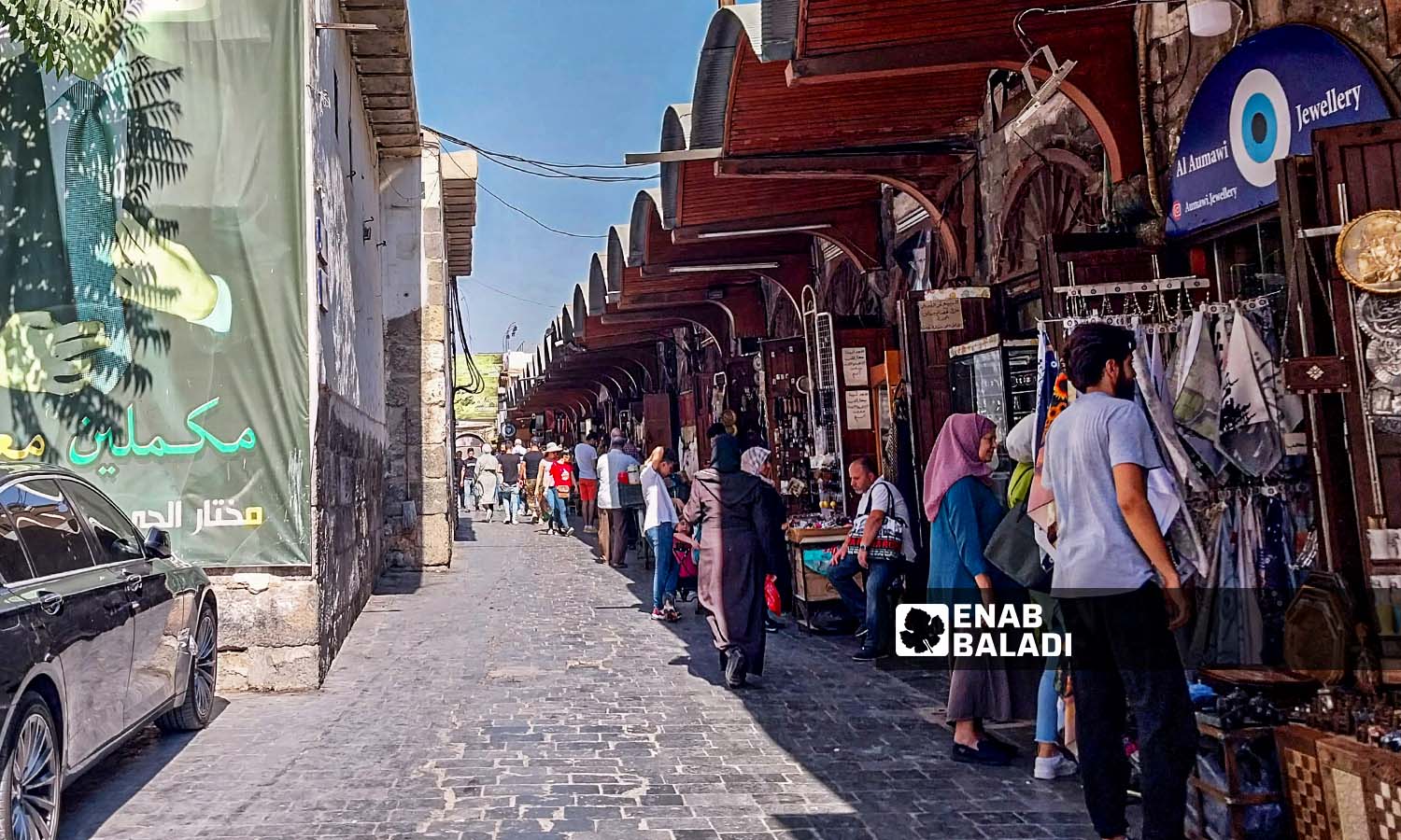 مارة أمام محال تجارية في حي القيمرية بدمشق - 26 من تموز 2023 (عنب بلدي / سارة الأحمد)
