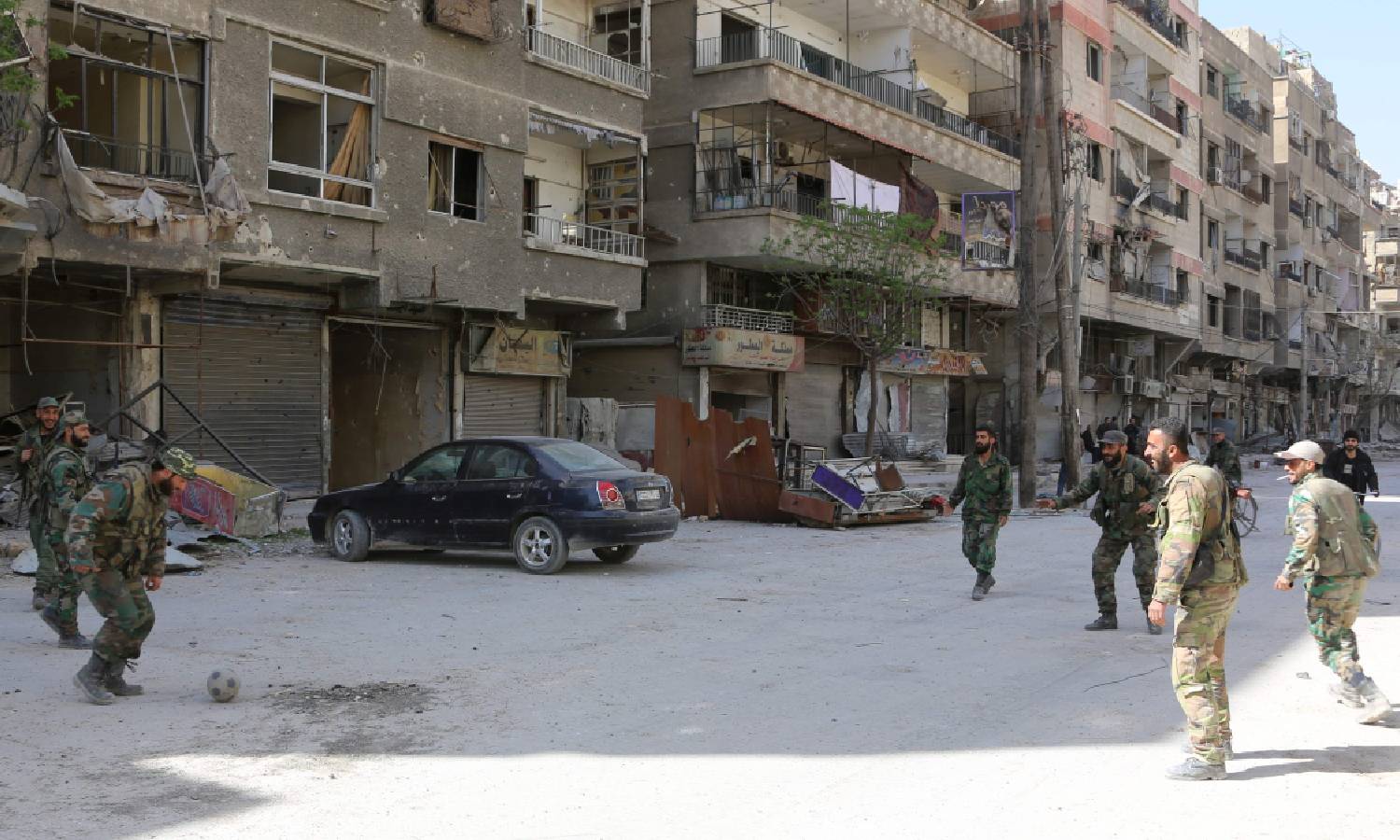 جنود في جيش النظام السوري يلعبون كرة القدم في شوارع مدينة عين ترما بريف دمشق بعد خروج المعارضة منها في آذار 2018 (سانا)