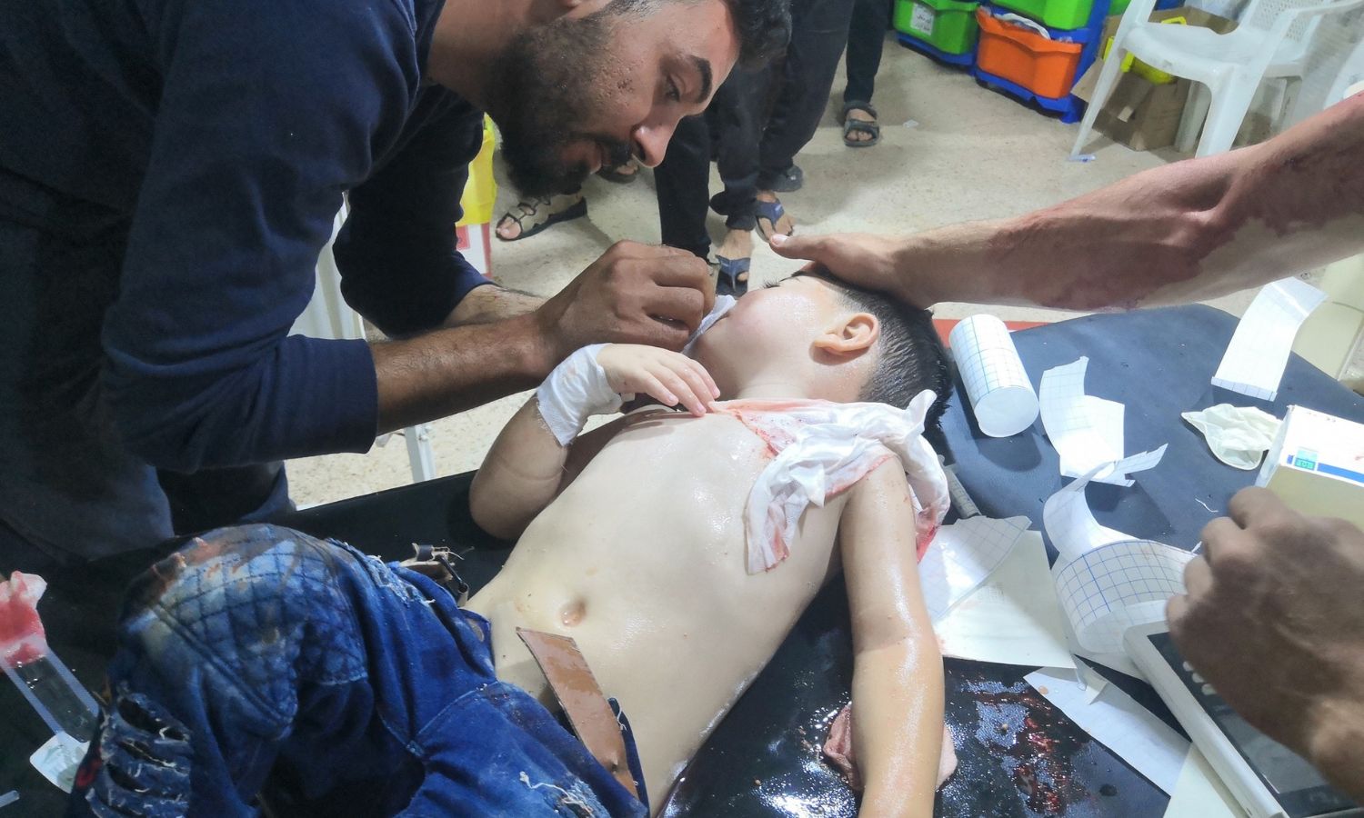 طفل يتلقى العلاج بعد إصابته بقصف من قبل قوات النظام وروسيا على بلدة إحسم جنوبي إدلب- 22 من آب 2023 (الدفاع المدني السوري)