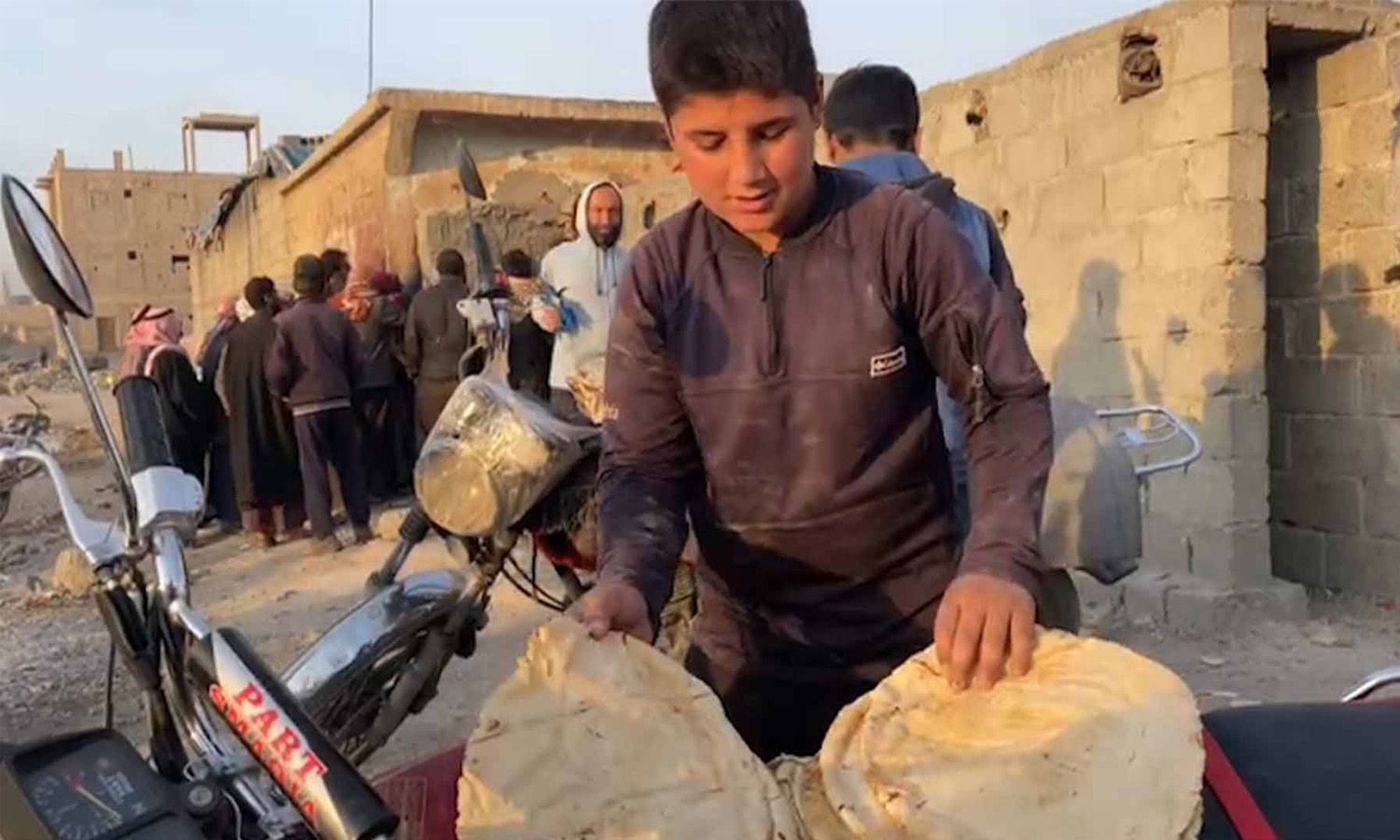 مدنيون يشترون الخبز من أحد الأفران في بلدة غرانيج شرقي دير الزور (نورث برس)
