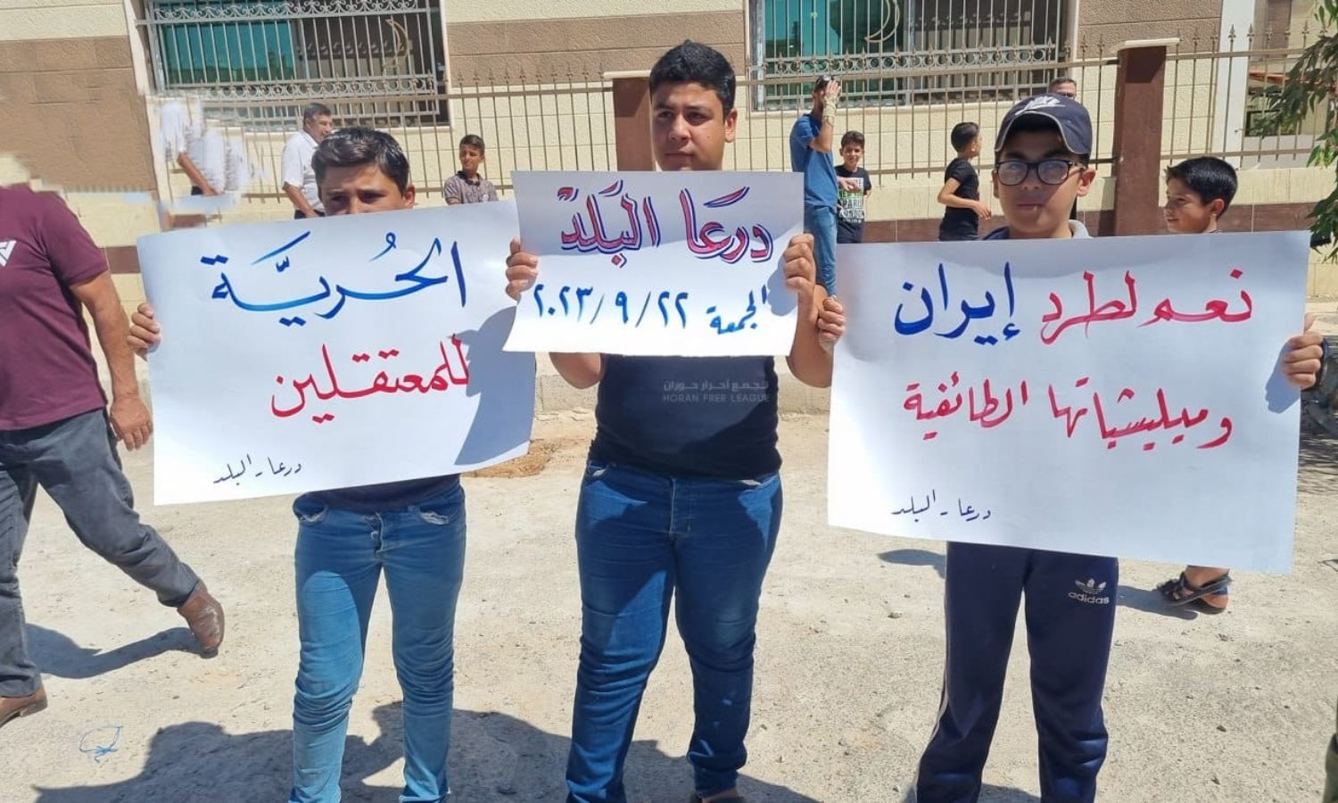 محتجون يرفعون لافتات مناوئة للنظام السوري والميليشيات الإيرانية الداعمة له في سوريا- 22 من أيلول 2023 (صوت الجنوب/ فيس بوك)