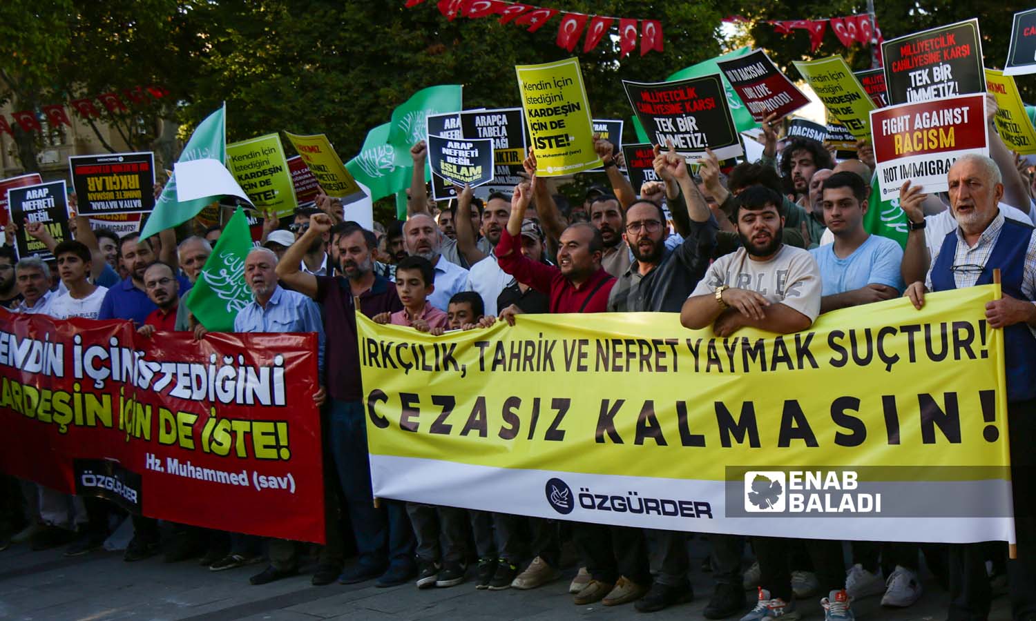 ناشطون يرفعون لوحات تندد بالعنصرية، وكتب عاللوحة الصفراء عبارة"من يحرض على العنصرية وينشر الكراهية فهو مجرم، ولا ينبغي أن يبقى دون عقاب"- اسطنبول 16 من أيلول 2023 (عنب بلدي- يوسف حمّص)
