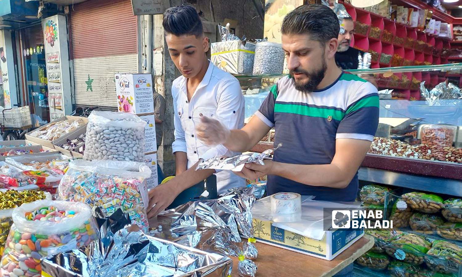 عامل يقوم بتجهيز صرر حلويات في سوق الجزماتية بدمشق-  27 أيلول 2023 (عنب بلدي- سارة الأحمد)