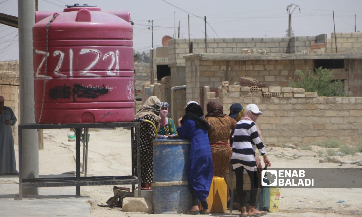 فتيات ونساء ينتظرن لملئ "بيدونات" بمياه الشرب من خزان في مدينة الحسكة شمال شرقي سوريا منذ 2019- آب 2023 (عنب بلدي/ ريتا أحمد)