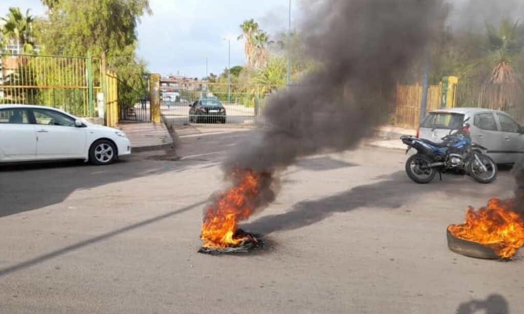 محتجون يغلقون مدخل مبنى الاتحاد الرياضي في السويداء اعتراضًا على زيارة رئيسه فراس معلا لتنظيم مسيرة موالية للنظام- 16 من تشرين الأول 2023 (السويداء 24/ فيس بوك)