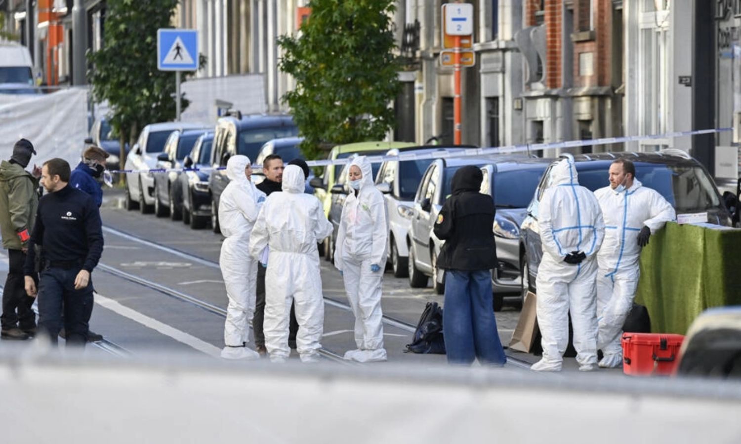 ضباط شرطة بلجيكيون من مصلحة الطب الشرعي يتجمعون في بمنطقة سكاربيك في بروكسل- 17 من تشرين الأول 2023 (AFP)