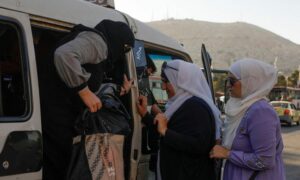 نساء يستقلن حافلة نقل صغيرة "سيرفيس" في العاصمة السورية، دمشق- 20 من حزيران 2022 (رويترز)