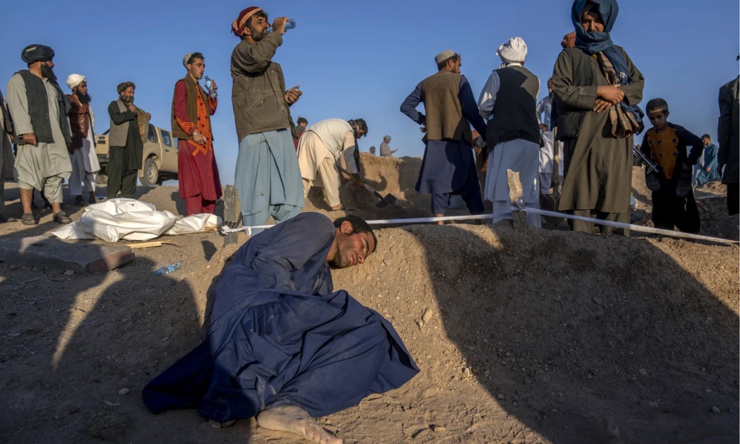 رجل أفغاني يضع رأسه على قبر زوجته التي توفيت بسبب الزلزال في مقاطعة هرات غرب أفغانستان -9 من تشرين الأول 2023 (AP)