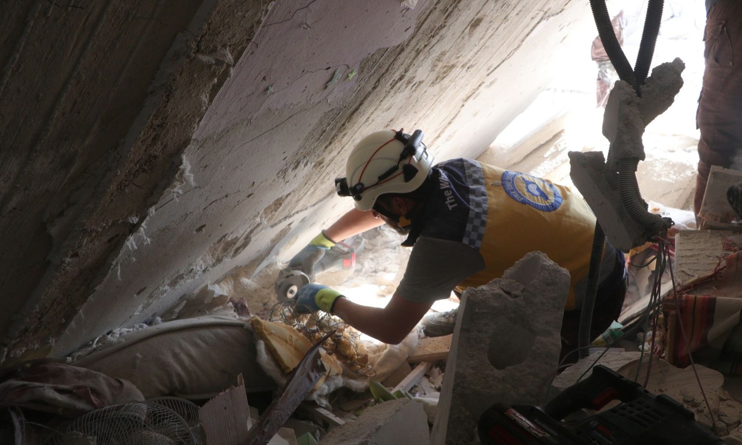 عنصر من الدفاع المدني السوري يرفع الأنقاض الناتجة عن القصف على إدلب في 8 من تشرين الأول 2023 (الدفاع المدني/ فيس بوك)