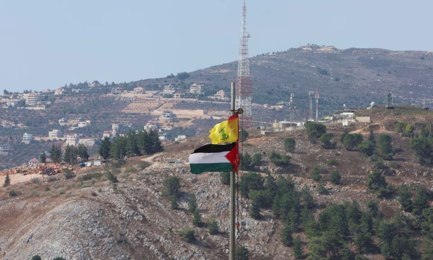 علم فلسطين وراية "حزب الله" اللبناني بالقرب من الحدود مع إسرائيل جنوبي لبنان- 9 من تشرين الأول 2023 (رويترز/ عزيز طاهر)