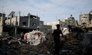 فلسطينيون يتفقدون مواقع الغارات الإسرائيلية التي دمرت المنازل في خانيونس جنوبي قطاع غزة- 27 من تشرين الأول 2023 (رويترز)
