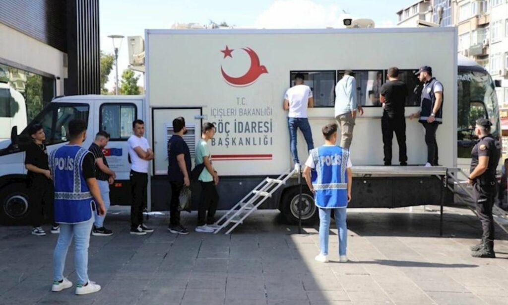 مهاجرون ينظر إلى بياناتهم في نقطة الهجرة المتنقلة في اسطنبول- 17 من أيلول (رئاسة الهجرة التركية)