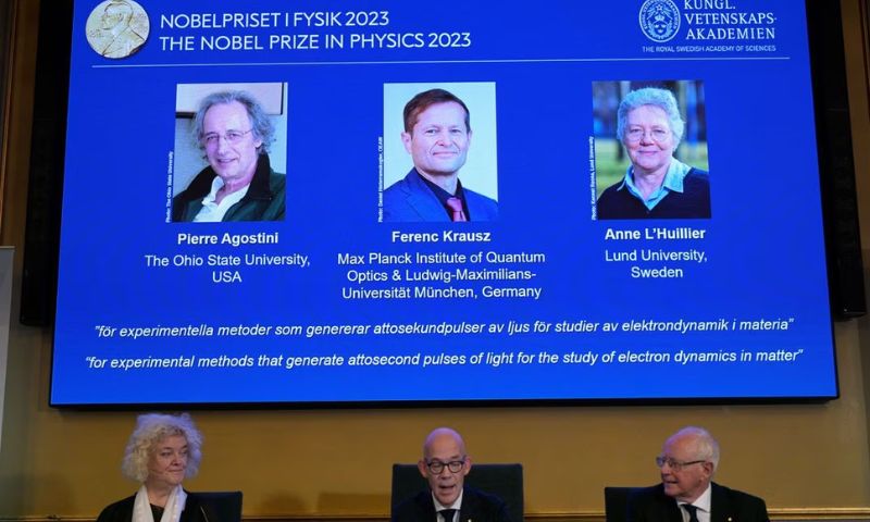 هانز إليجرين، السكرتير الدائم للأكاديمية الملكية للعلوم، يحيط به إيفا أولسون وماتس لارسون، الأعضاء، خلال الإعلان عن الفائزين بجائزة "نوبل" لهذا العام في الفيزياء، في الأكاديمية الملكية للعلوم في ستوكهولم- 3 تشرين الأول 2023 (رويترز)