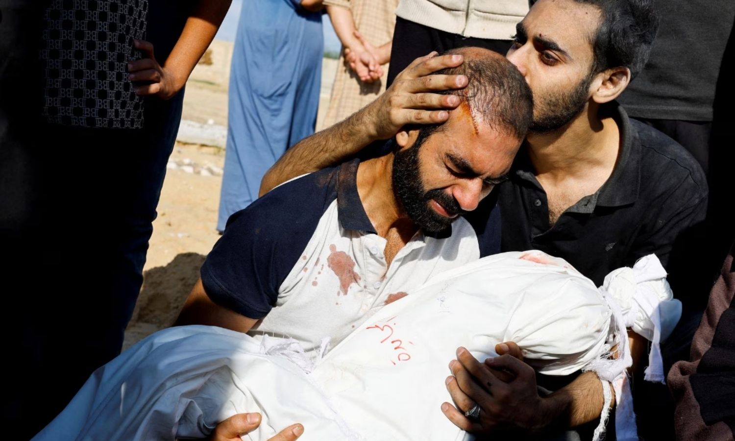 والد الطفلة ألما المجايدة 3 أعوام يحضنها خلال جنازتها في خان يونس بجنوب قطاع غزة- 19 من تشرين الأول (reuters)
