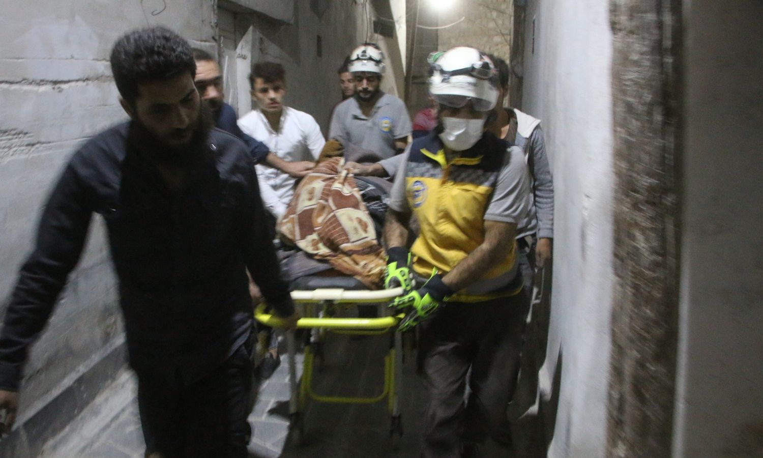 عناصر "الدفاع المدني السوري" ينقلون جثمان امرأة قُتلت بغارات روسية جنوبي إدلب- 13 من تشرين الأول 2023 (الدفاع المدني)