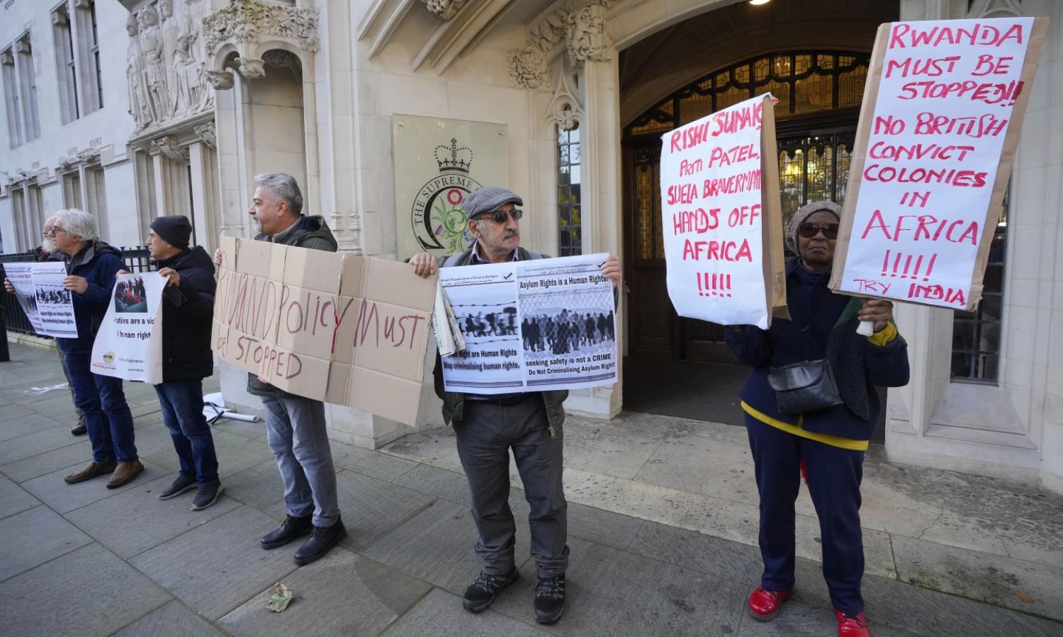 متظاهرون يقفون خارج المحكمة العليا في لندن للتنديد بسياسة الحكومة البريطانية ضد طالبي اللجوء- 15 تشرين الثاني 2023 (ap)