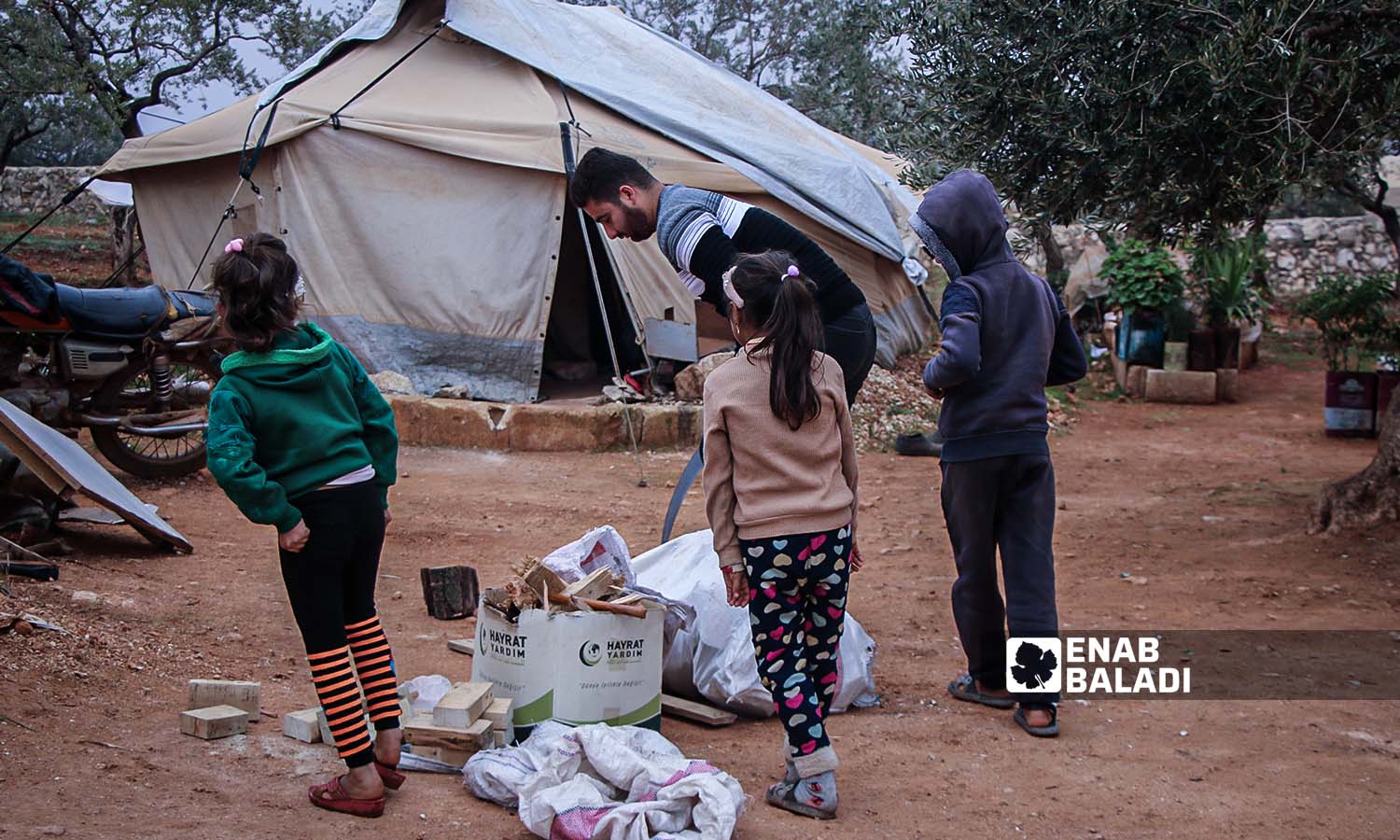 عائلة تجمع الحطب لاستخدامه للتدفئة في مخيم الخير بريف إدلب شمالي سوريا - 22 تشرين الثاني 2023(عنب بلدي/إياد عبد الجواد)