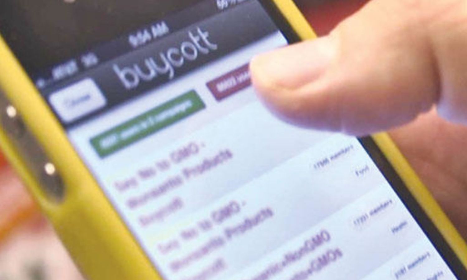 أحد المستخدمين يحمل هاتف ذكي ويظهر على شاشته واجهة تطبيق "Buycott"- 2013 (فوربس)