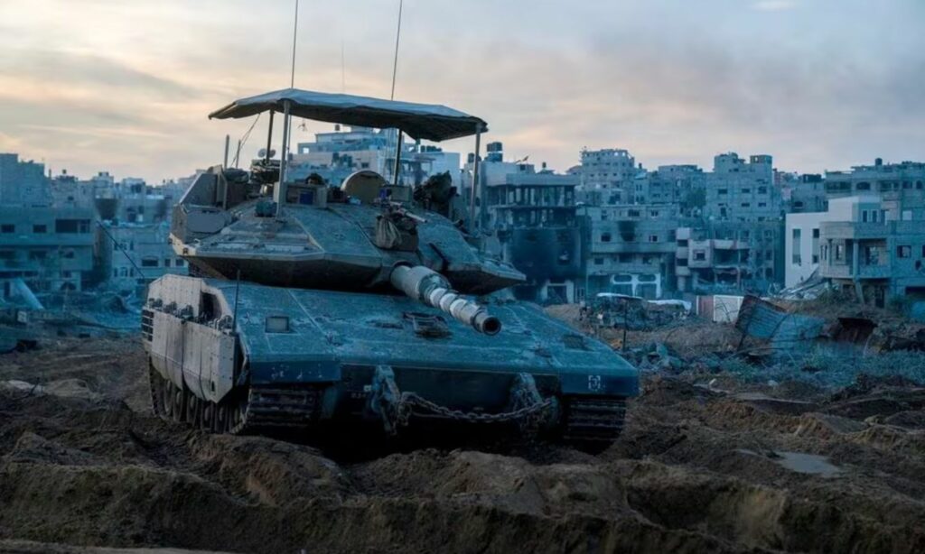 جندي إسرائيلي ينظر من دبابة "ميركافا" في غزة، خلال الاجتياح البري الإسرائيلي للقطاع- 7 من كانون الأول 2023 (رويترز)