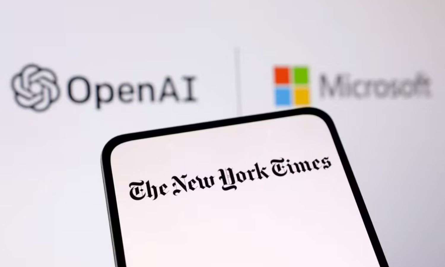 شعار صحيفة "نيويورك تايمز" على هاتف ذكي وشعاري "OpenAI" و"Microsoft" بالخلفية- 27 كانون الأول 2023 (رويترز)