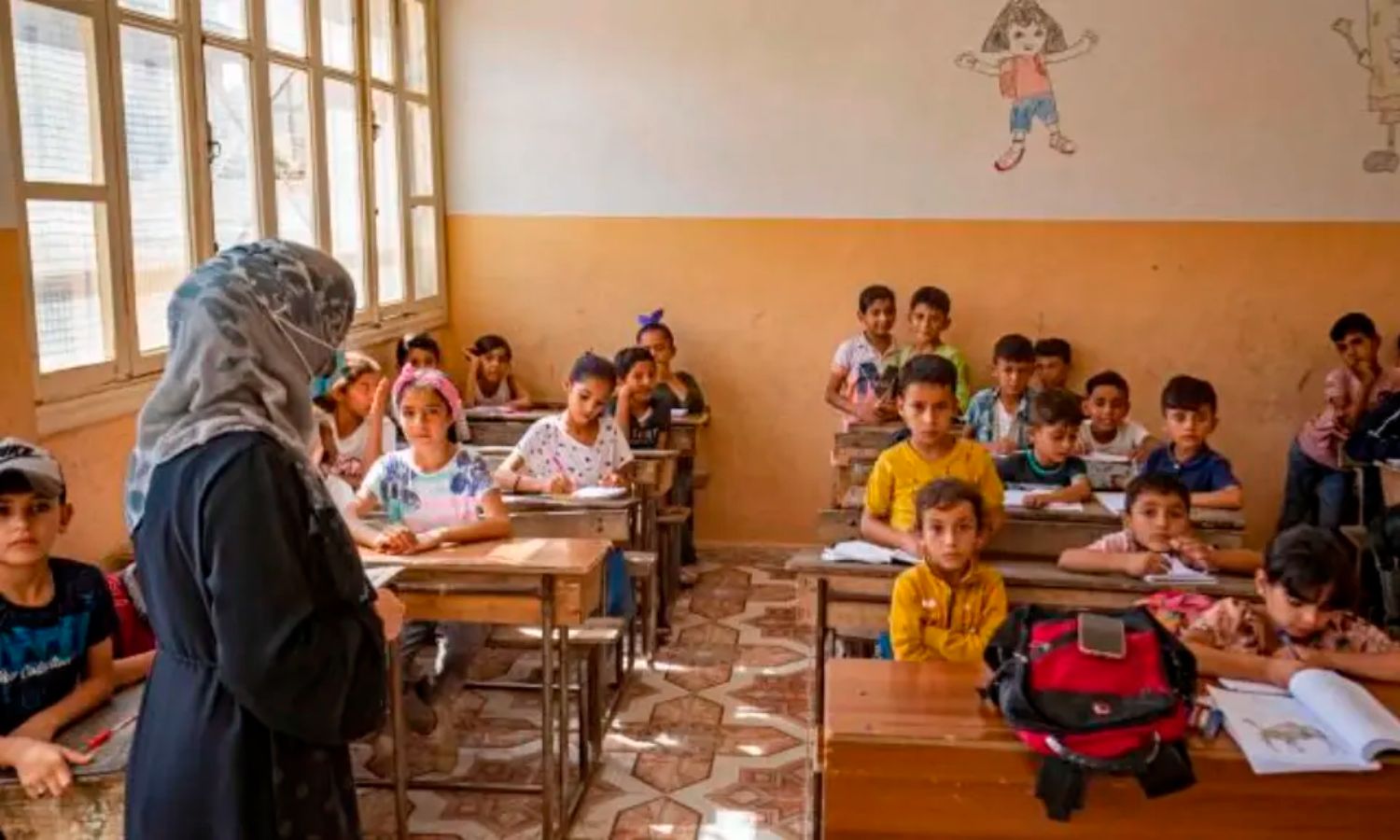 تلاميذ سوريون يحضرون فصلًا دراسيًا مع بدء العام الدراسي الجديد في مدرسة بمدينة الرقة شمالي سوريا - 21 من أيلول 2022 (AFP/ دليل سليمان)
