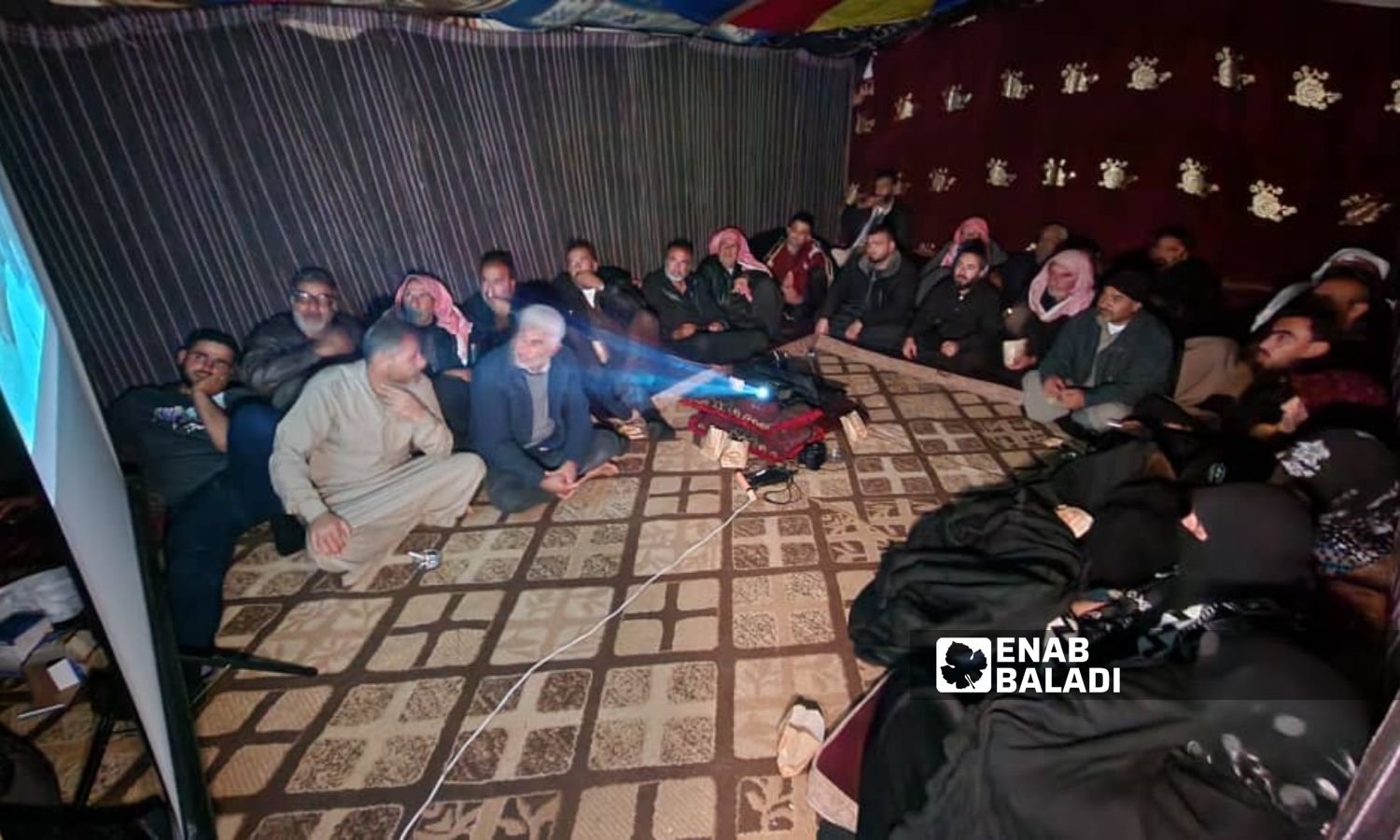 اجتماع لمهجرين داخل خيمة في مخيم "التح" شمالي إدلب - كانون الأول 2023 (عنب بلدي)