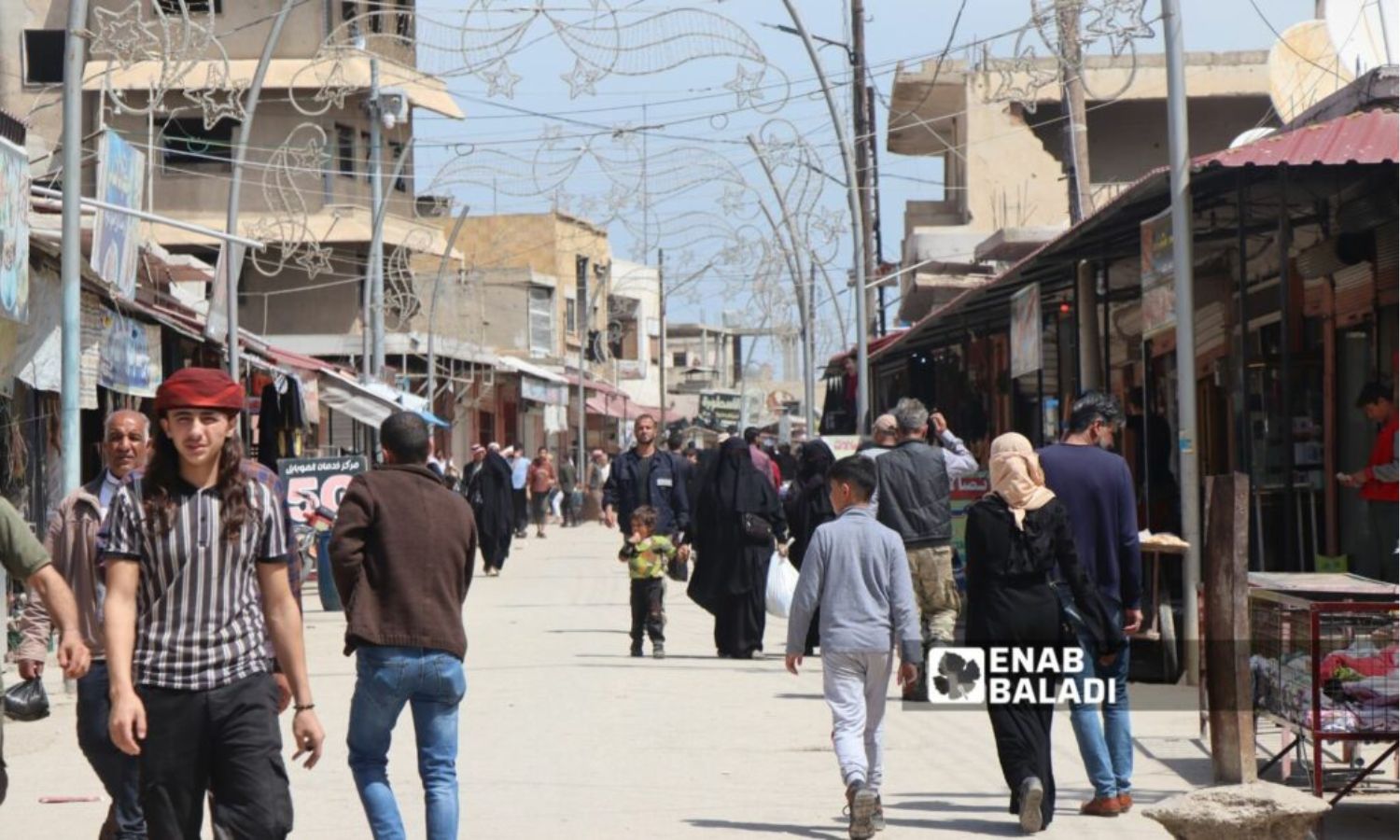 مواطنون في أحد شوارع مدينة رأس العين شمال غربي الحسكة- تموز 2023 (عنب بلدي/ حسين شعبو)