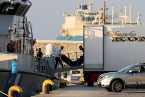 أشخاص ينقلون جثث مهاجرين توفوا في حادثة انقلاب قاربهم قبالة السواحل اليونانية - 15 من حزيران 2023 (رويترز) 
