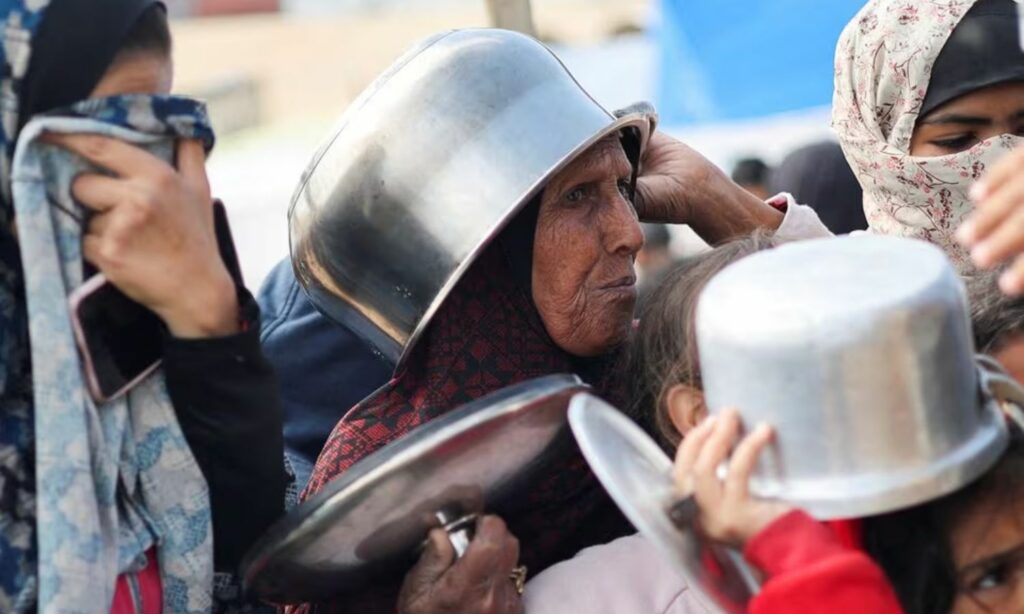 نازحون فلسطينيون ينتظرون الحصول على حصة من الطعام وسقط أزمة غذاء حادة جراء الحرب الإسرائيلية المتواصلة على غزة- 28 من شباط 2024 (رويترز)