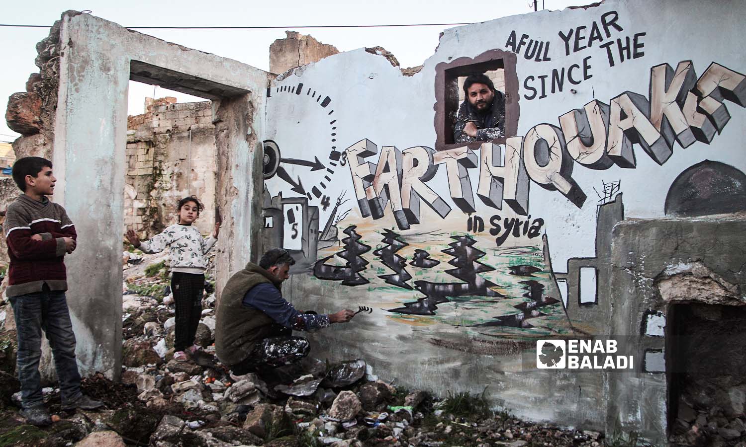 شبان يرسمون جدارية  في مدينة بنش بريف إدلب إحياء لذكرى كارثة 6 من شباط 2023  - 6 من شباط 2024 (عنب بلدي/ عبد الكريم الثلجي)