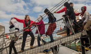 عمال الإغاثة يساعدون اللاجئين والمهاجرين على النزول من سفينة إنقاذ في صقلية، إيطاليا- 25 كانون الثاني 2018 (سانتي بالاسيوس / AP)
