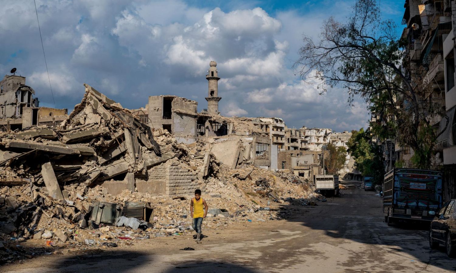 فتى سوري أمام بناء مدمر في حي السكر جنوبي حلب- شباط 2019 (ناشينوال جيوغرافيك)