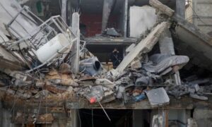 فلسطينيون يتفقدون موقع غارة إسرائيلية على منزل في رفح، جنوبي قطاع غزة- 27 من شباط 2024 (رويترز)