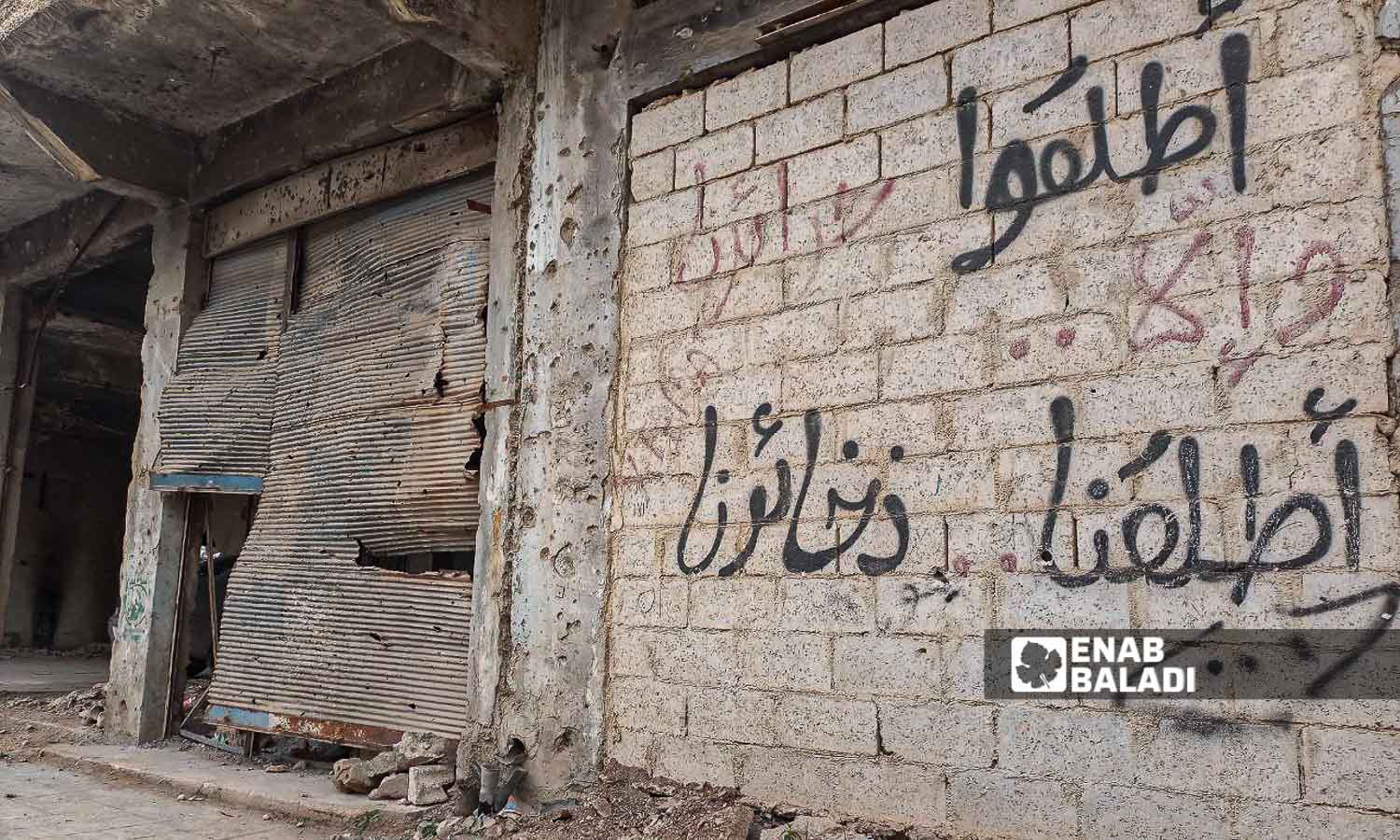 " أطلقوا حرائرنا وإلا أطلقنا ذخائرنا"  عبارة كتبت على جدار مدمر في درعا المحطة  - 17 من آذار 2024 (عنب بلدي/ سارة الأحمد)