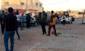 مدنيون يقفون بجانب سيارات عسكرية لفصائل محلية في بلدة أم المياذن بريف درعا الشرقي- 7 من آذار 2023 (غرف أخبار محلية/ واتساب)
