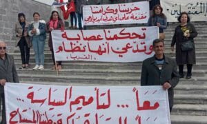 متظاهرون يرفعون شعارات مبادرة المناطق الثلاث من أمام ضريح سلطان باشا الأطرش في بلدة القريا بالسويداء- 8 من آذار 2023 (Moudar Al Debis- فيس بوك)