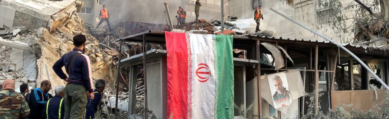 العلم الإيراني وصورة قاسم سليماني أمام ركام القنصلية الإيرانية بدمشق- 1 من نيسان 2024 (رويترز)
