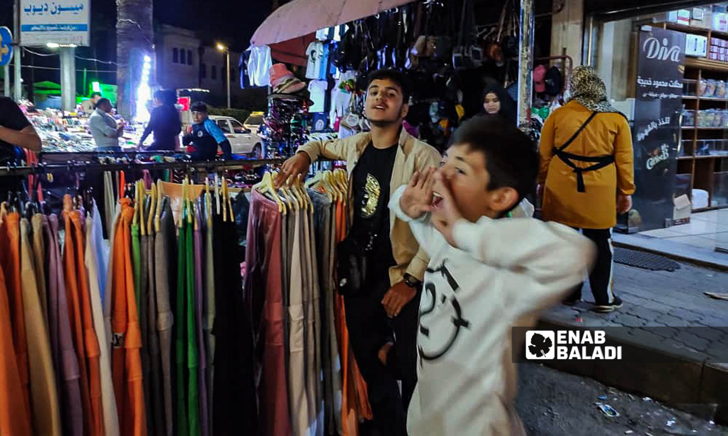 أطفال بائعون ملابس في سوق "العنابة" قبل عيد الفطر في مدينة اللاذقية شمال غربي سوريا - 7 من نيسان 2024 (عنب بلدي/ليندا علي)