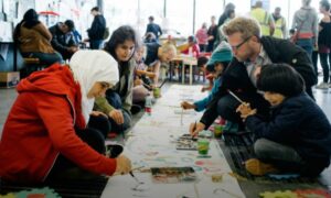 متطوعون يرسمون مع الأطفال اللاجئين ي محطة قطار 
