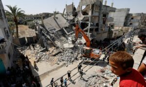 فلسطينيون يتفقدون موقع غارة إسرائيلية على أحد المباني في رفح جنوبي قطاع غزة- 2 من نيسان 2024 (رويترز)