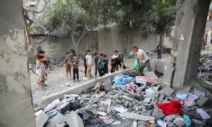 فلسطينيون تفقدون موقع غارة إسرائيلية في رفح- 25 من نيسان 2024 (رويترز)